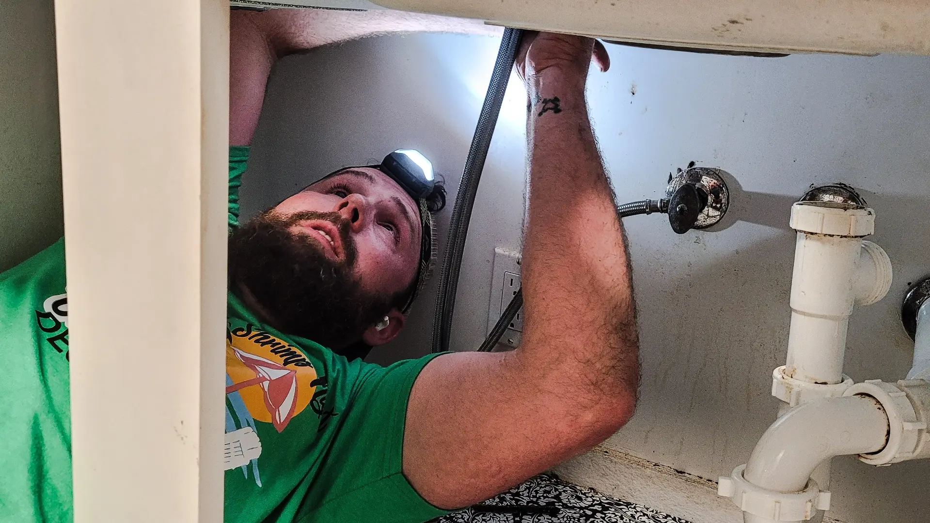 Sewer Camera Inspection: CCTV Pipe Light Diagnosis Toronto GTA Plumber shining light under sink during sewer camera pipe inspection in Toronto GTA, CCTV drain diagnosis