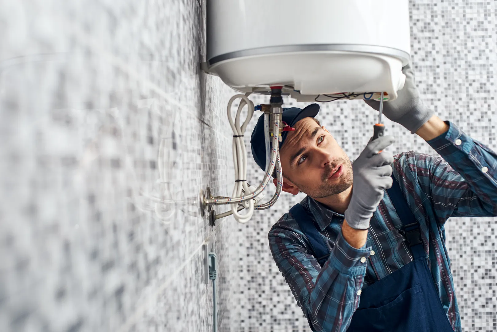 Water Heater Repair and Replacement: Electric Boiler Installation Toronto Worker installing electric heating boiler during water heater replacement service in Toronto GTA home